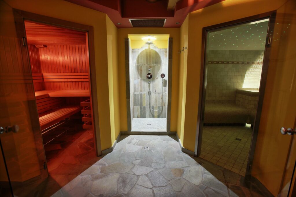 Foto frontale dell'area wellness, visibili sauna, doccia emozionale e bagno turco